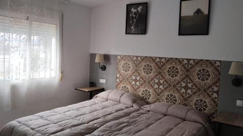 a bedroom with a tufted bed and a window at El Rincón del Olivo in Cartagena