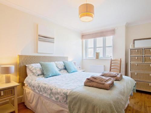 a bedroom with a bed with blue pillows on it at 2 Bed in Bridport oc-dc015 in West Bay