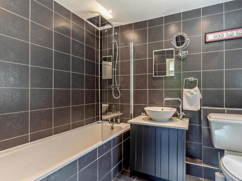 a bathroom with a sink and a tub and a toilet at 4 Bed in Braunton oc-56111 in Croyde