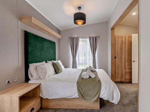 a bedroom with a large bed with a green wall at 2 Bed in Newport oc-94717 in Nevern