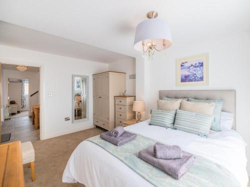 a bedroom with a large white bed with towels on it at 2 Bed in Tywyn oc-dy052 in Tywyn