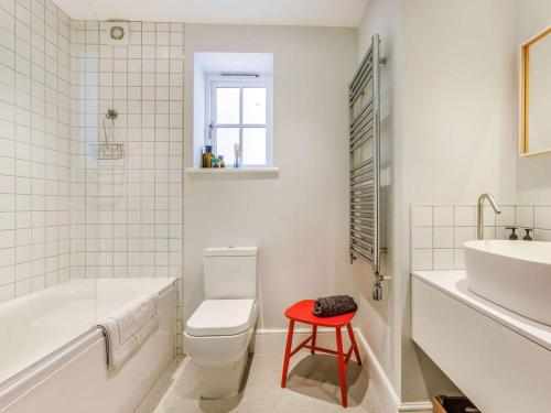 a bathroom with a white toilet and a red stool at 4 Bed in Bideford oc-88876 in Appledore