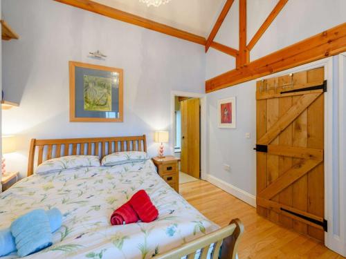 a bedroom with a large bed and a wooden door at 2 Bed in Colwyn Bay oc-74147 in Eglwys-Fâch
