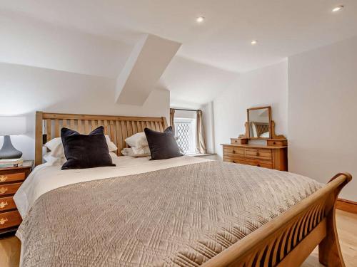 a bedroom with a large bed with black pillows at 1 Bed in Barnstaple oc-91612 in Bishops Tawton