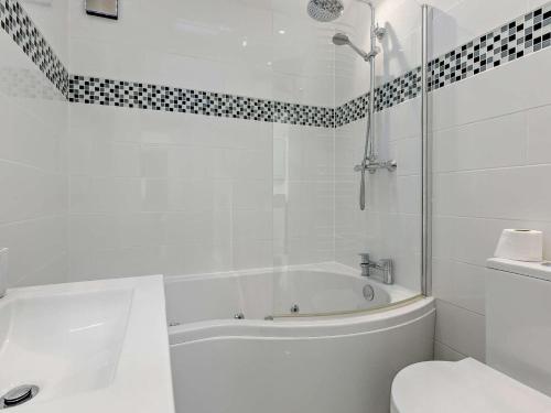 a white bathroom with a tub and a toilet at 2 Bed in Brixham oc-90912 in Brixham