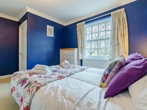 a bedroom with blue walls and a large bed at 3 Bed in Richmond oc-90578 in Catterick Bridge