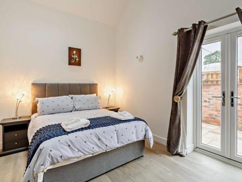 a bedroom with a bed and a sliding glass door at 2 Bed in Wakefield oc-93235 in Crofton