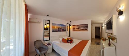 a bedroom with a bed and a chair in a room at Hotel Sunquest in Venus