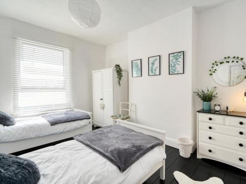 a bedroom with two beds and a dresser at 5 Bed in Ilfracombe oc-89563 in Ilfracombe