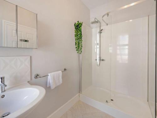 a white bathroom with a tub and a sink at 5 Bed in Ilfracombe oc-89563 in Ilfracombe