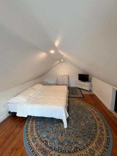 a bedroom with a white bed and a rug at Large King Suite Completely Private Space Stay close enough to Newport without the Noise in Portsmouth