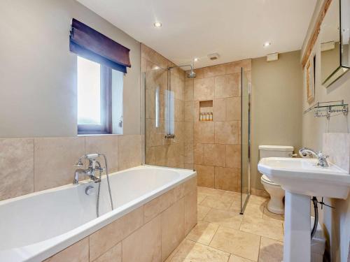 a bathroom with a tub and a sink and a toilet at 3 Bed in Heathfield oc-93718 in Dallington