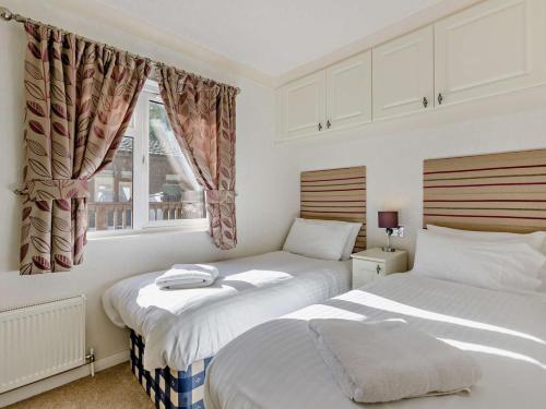a bedroom with two beds and a window at 3 Bed in Okehampton oc-95636 in Okehampton