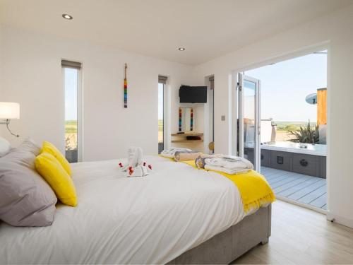 a large white bedroom with a large bed with yellow sheets at 1 Bed in Ilfracombe oc-52915 in Ilfracombe