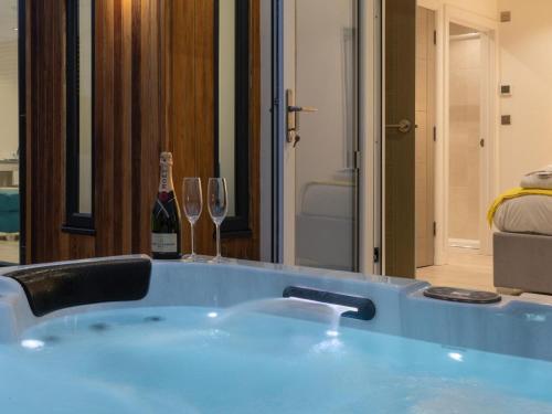 a bath tub with two wine glasses and a bottle of wine at 1 Bed in Ilfracombe oc-52915 in Ilfracombe