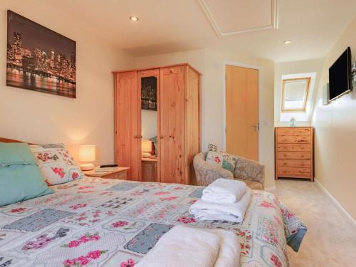 a bedroom with a bed and a chair and a dresser at 3 Bed in Watchet oc-37336 in Watchet