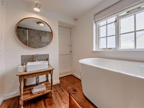 a bathroom with a large tub and a mirror at 2 Bed in Bideford oc-52863 in Appledore