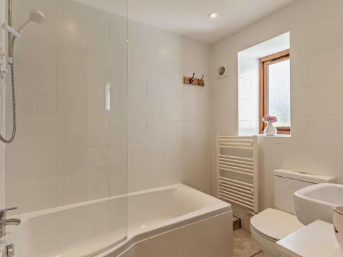 a white bathroom with a tub and a sink at 1 Bed in Ilfracombe oc-43641 in Berrynarbor