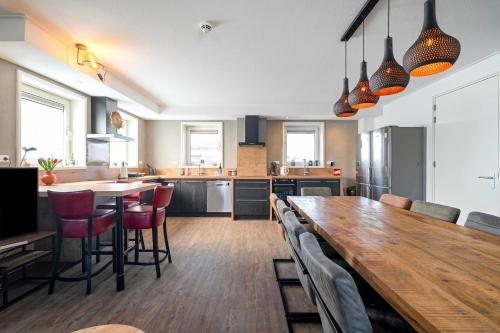 a kitchen with a large wooden table and chairs at Guesthouse Eindeloos in 't Zand - North Holland in 't Zand