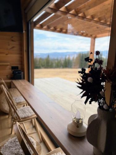 a wooden table with a vase of flowers on it at Yatak in Vatra Dornei