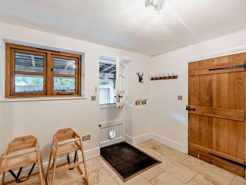 a room with two chairs and a wooden door at 4 Bed in Ilfracombe oc-95899 in Berrynarbor
