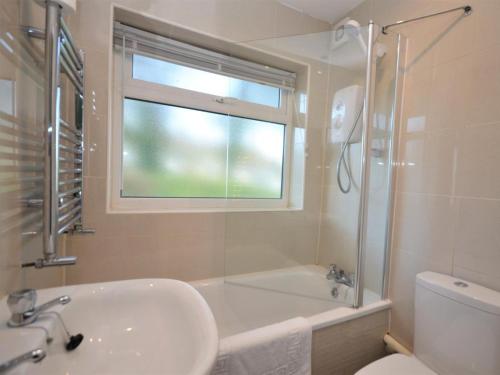 a bathroom with a sink and a tub and a window at 2 Bed in Brixham oc-bx054 in Brixham