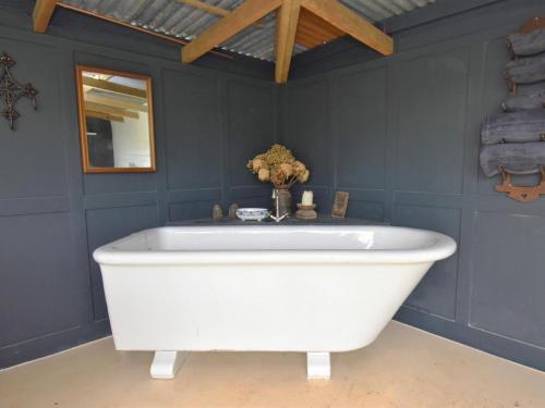 a large white bath tub in a blue bathroom at 1 Bed in Llandysul oc-85415 in Rhyd Owen
