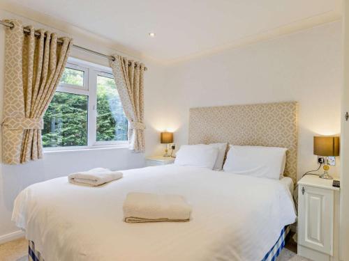 a bedroom with a large white bed with two towels on it at 2 Bed in Okehampton oc-74242 in Okehampton