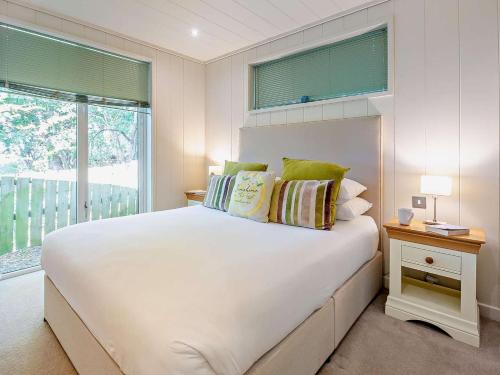 a bedroom with a large white bed and a window at 2 Bed in Conwy oc-50284 in Llangelynin