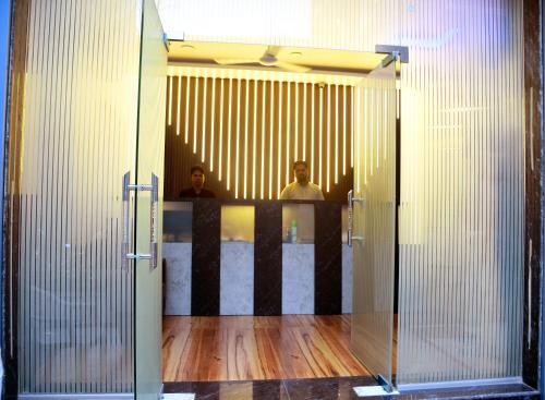 two people standing in front of a mirror at Hotel Edition Blue in Mumbai