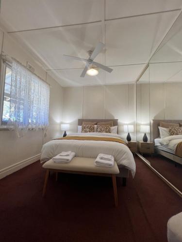 a bedroom with a large bed with a ceiling fan at Cosy Heritage Cottage in Ararat