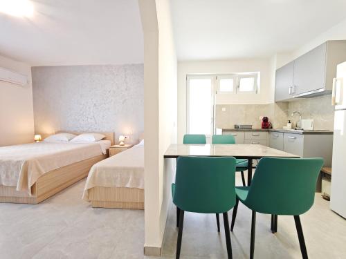 a bedroom with a bed and a table and chairs at Hana Accommodation in Sveti Stefan