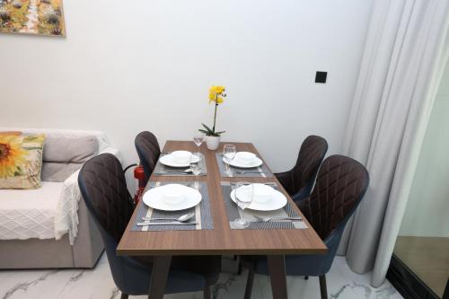 a dining room table with chairs and a table and a couch at Maryah Island Luxe 1 Bed Junior by Central Stay in Abu Dhabi