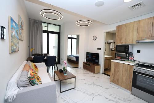 a living room with a couch and a kitchen at Maryah Island Luxe 1 Bed Junior by Central Stay in Abu Dhabi