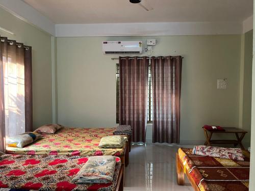 a bedroom with two beds and a window at Artham The River View in Gokarna