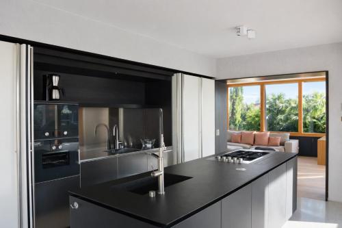 a kitchen with a black counter top and a living room at Pool Villa Lazise in Lazise