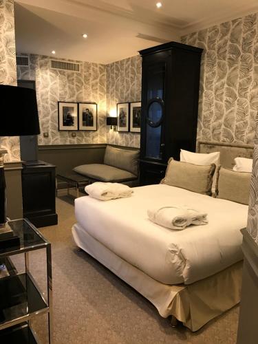 a bedroom with a large bed and a couch at Hôtel George Washington in Paris