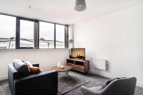 a living room with two chairs and a television at Smart 1 Bed Apartment in Central Wrexham in Wrexham