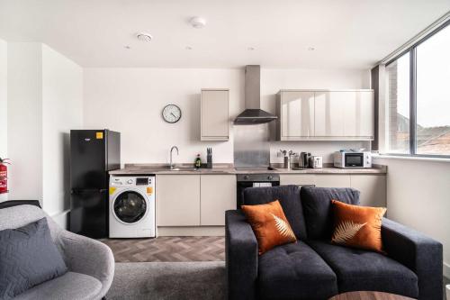 a living room with a couch and a kitchen at Smart 1 Bed Apartment in Central Wrexham in Wrexham