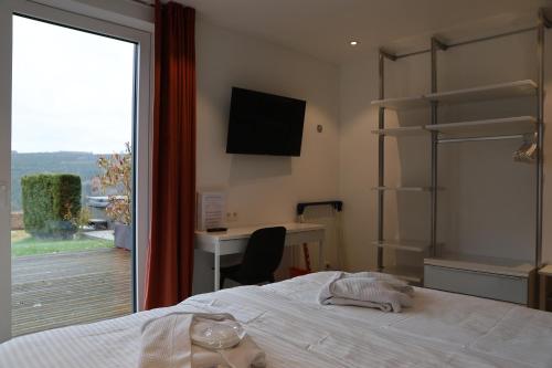 a bedroom with a bed and a desk and a window at The View in Francorchamps