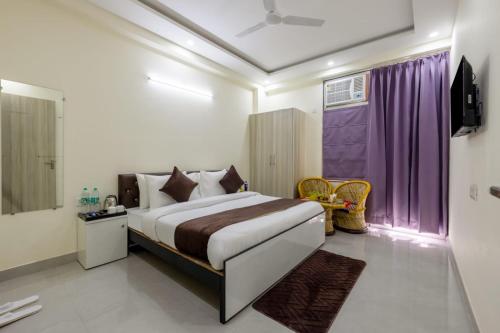 a bedroom with a bed and a purple curtain at Expressway Hotel - Yashobhoomi, Dwarka in New Delhi
