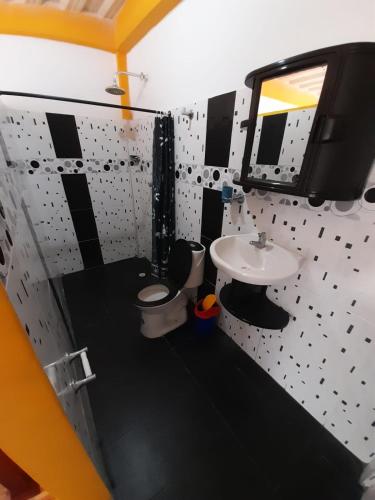 a bathroom with a sink and a toilet and a mirror at Hotel Pablo's in Tumaco