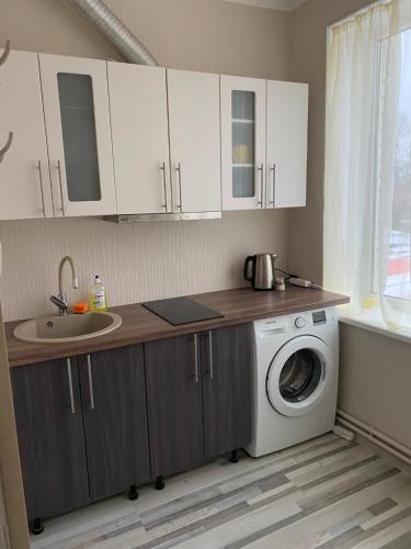 a kitchen with a washing machine and a sink at Straume AP in Valmiera
