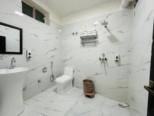 a white bathroom with a toilet and a sink at Hotel Panna Haveli in Jaipur