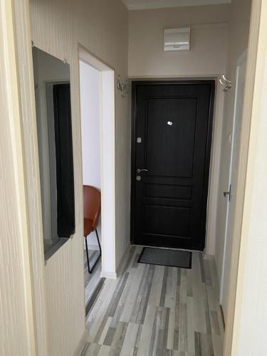 a hallway with a black door and a television at Straume AP in Valmiera