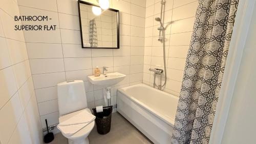 a bathroom with a sink and a toilet and a bath tub at Fjordhotellet in Lysekil