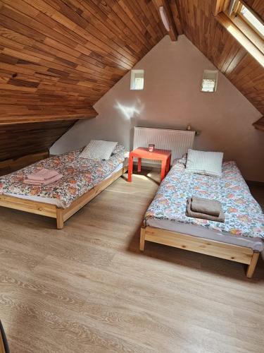 ein Zimmer mit zwei Betten und einem Tisch darin in der Unterkunft Forest Mood in Braine-le-Château