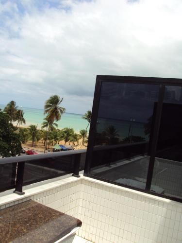a view of the beach from the balcony of a building at Mar do Cabo Branco Residence in João Pessoa