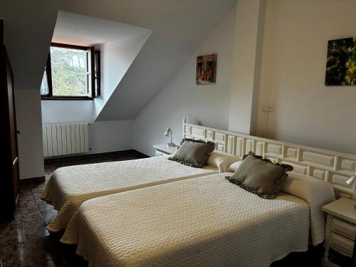 two beds in a white room with two beds at Hotel Solatorre in Comillas