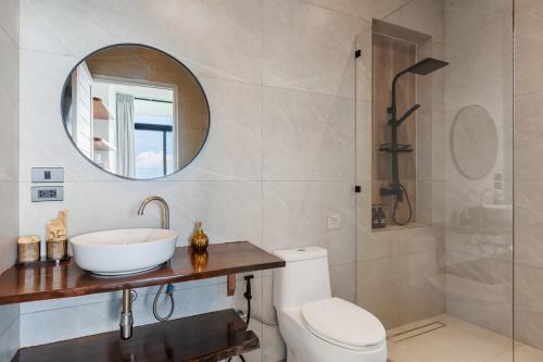 a bathroom with a toilet and a sink and a mirror at Shamgrila - Panoramic Sea View in Ko Phangan